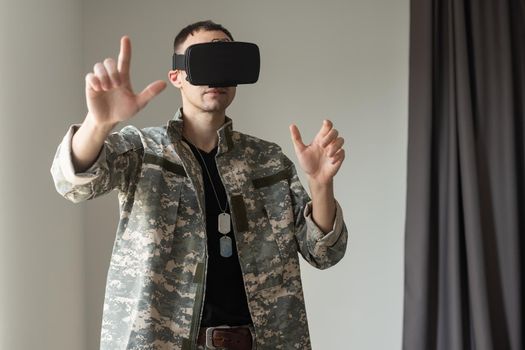 Military man trying to touch virtual objects while wearing a VR headset. Disability and modern gadgets.