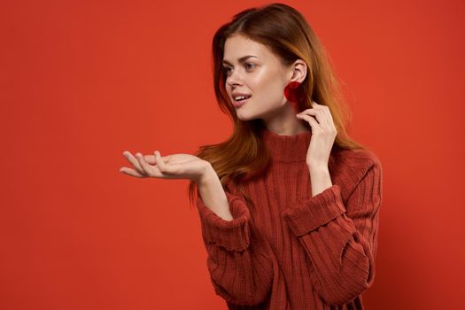 woman in red sweater earrings jewelry red background gesture with hands