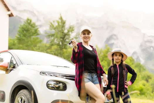Happy driver woman against mountains background. Summer vacations concept