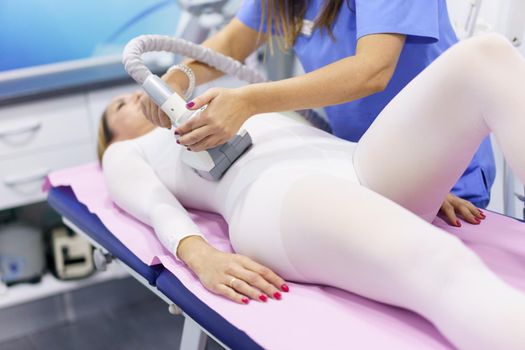 Woman in special suit having a anti cellulite belly massage with spa apparatus