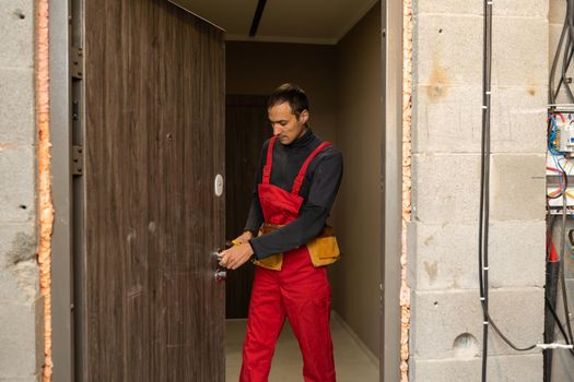 Male handyman carpenter at interior wood door lock installation