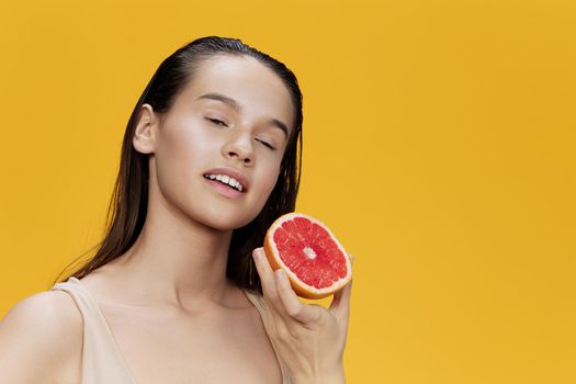 brunette eating grapefruit in hands smile vitamins diet isolated background