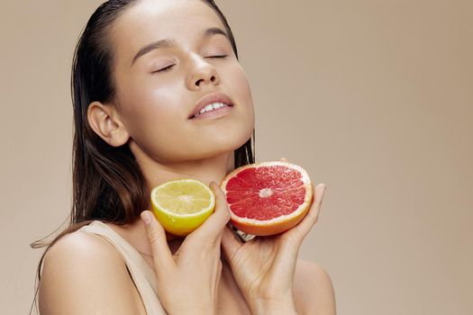 brunette grapefruit near face clean skin care health beige background