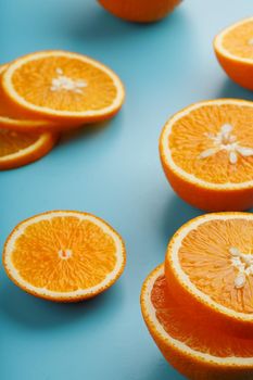 Slices and slices of orange pulp on a bright blue background as a textural background, the substrate. Full screen Flat lay, top view. Food background