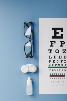 Ophthalmic Accessories Glasses and lenses with an Eye Test Chart for vision correction on a blue background