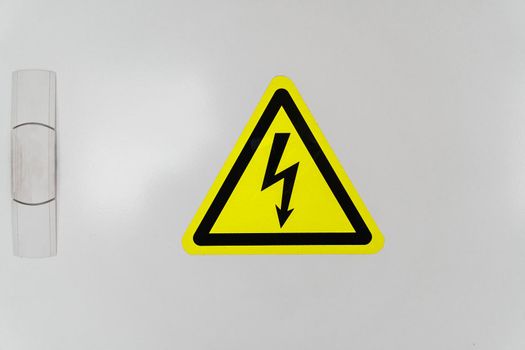 A shield with a yellow triangle and a lightning bolt signifies high voltage.