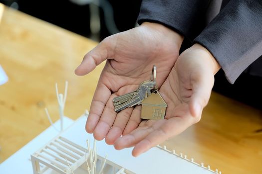 Real estate agent handing over house keys with approved mortgage application form and offer handshake