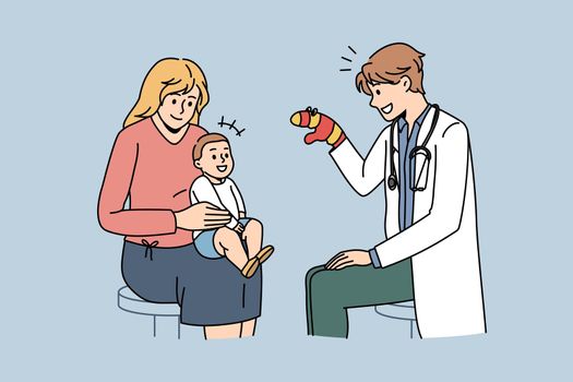 Pediatrician working with babies concept. Young smiling man pediatrician sitting and playing with small baby on mothers knees with mitten vector illustration