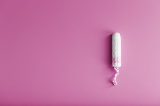 Hygienic tampon on a pink background with a free space