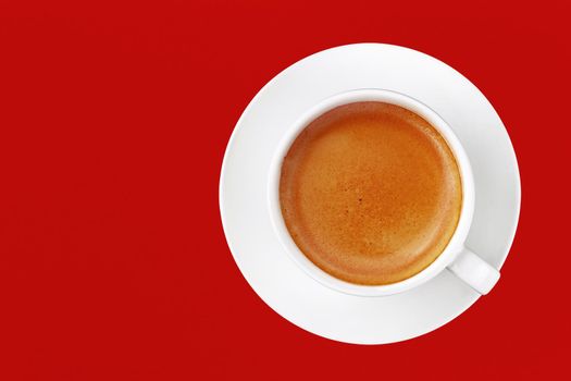 Full cup of espresso coffee on red