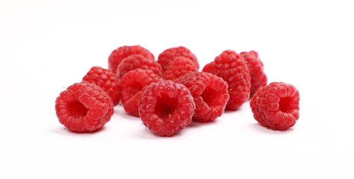 Close up group of fresh red ripe raspberry berries isolated on white background, low angle view