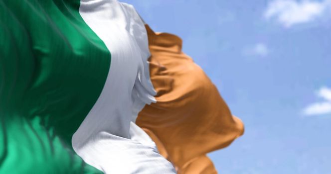 Detail of the national flag of Ireland waving in the wind on a clear day