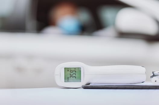 Don't forget to check your temperature. Shot of a thermometer on a table at a drive through vaccination site.