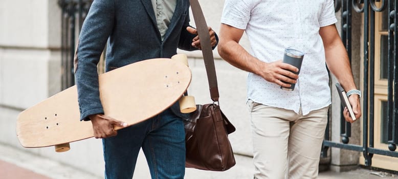 Cropped shot of two young businessmen walking through the city together
