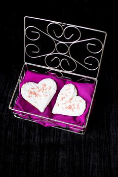 Cookies in the form of heart lies in a casket with pink cloth