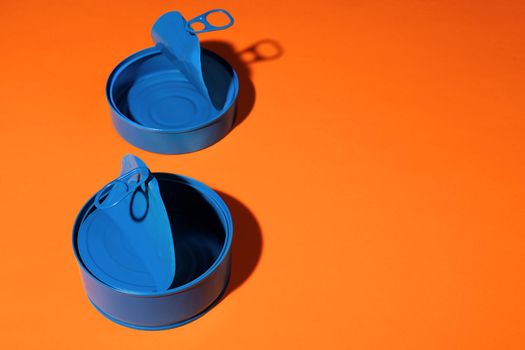 Aesthetic concept with blue painted tin can on orange background