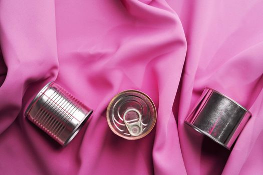 Tin can on pink silky fabric, aesthetic concept