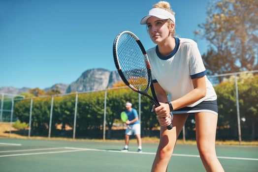 Champions play with heart and dedication. Cropped shot of an attractive young female tennis player playing together with a male teammate outdoors on a court.