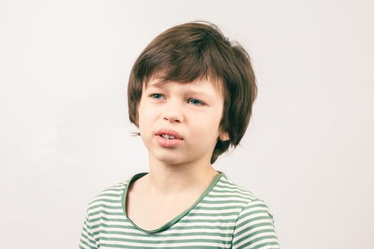 Portrait of Caucasian boy with unhappy bored face