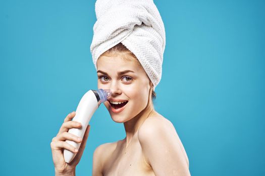 cheerful woman with a towel on her head massagers in hands dermatology clean skin