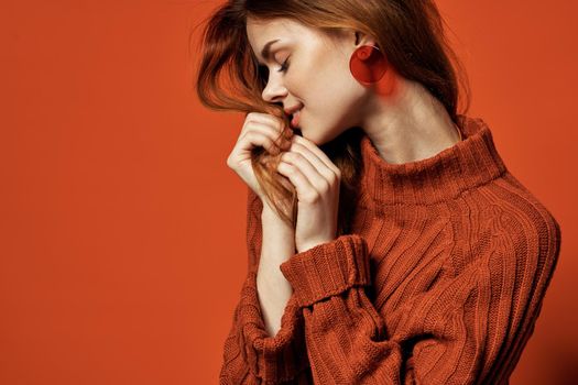 attractive red-haired woman red sweater earrings jewelry fashion