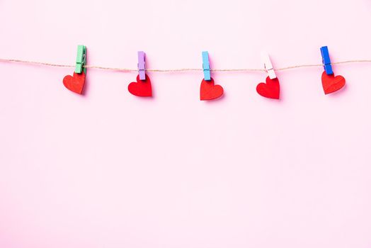 red heart-shaped valentines decoration hanging with wood clips