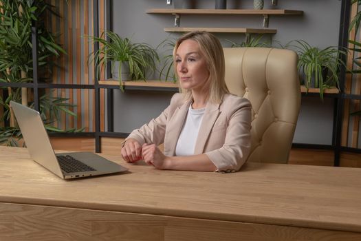 a girl at a computer sits on a chair business woman independent strong in a white suit