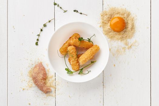 Deep-fried chicken sticks battered in egg and bread crumbs
