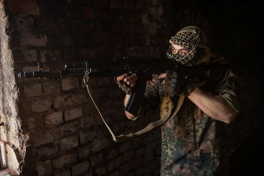 Arab soldier aiming with Kalashnikov AK-47 assault rifle