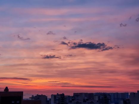 Sunset background with wonderful red,golden, yellow sky, Amazing purple and orange sky in evening during the sun going down above city.Dramatic sunset sky with clouds