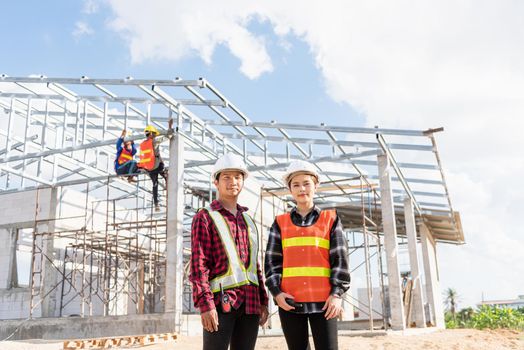 Architect and client standing at home building construction site