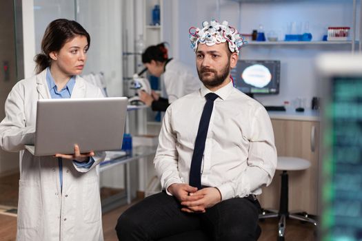 Researcher woman doctor typing neurological disease symptoms on laptop