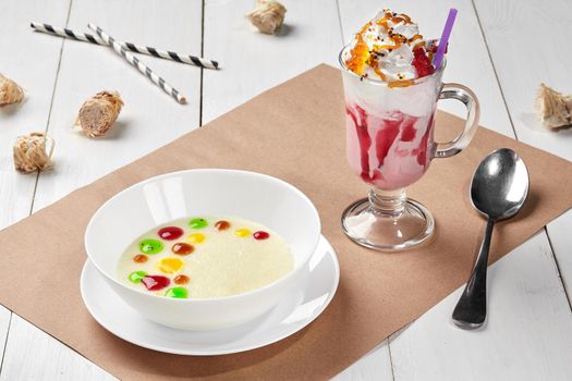 Sweet semolina porridge with fruit toppings and berry milkshake