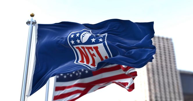 Inglewood, CA, USA, January 2022: The flag with the NFL logo waving in the wind with the US flag blurred in the background
