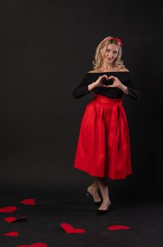 Girl standing around cardboard hearts symbol, flirting board, on the floor hearts lovely romance. holiday. event forever, frame in red dress girl, barefoot
