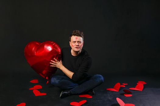 valentines heart red, inflatable balloon in hands, adventure. On a black background, the lifestyle giving