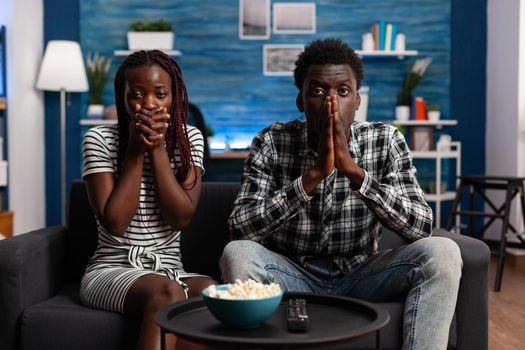 Shocked african american couple watching tragic news