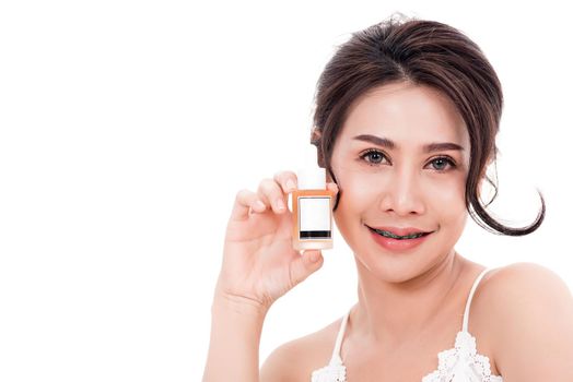 woman smiling she's holding bottle serum hair or skin care