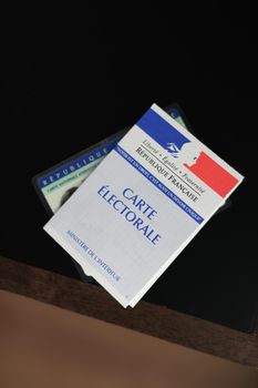 PARIS, FRANCE - MARCH 09, 2020: Hand holds a french electoral card and an identification card for voting