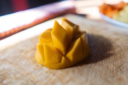 Close-up of diced mango on wooden cutting board