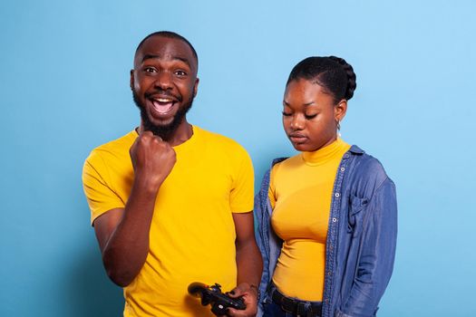Man beating woman at video games with controller on console