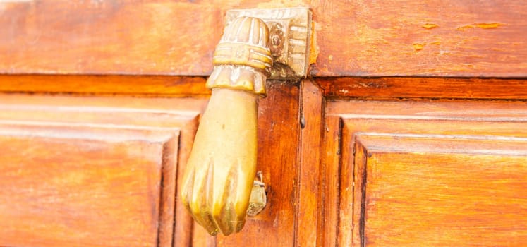 Door with brass knocker in the shape of a hand,  beautiful entrance to the house
