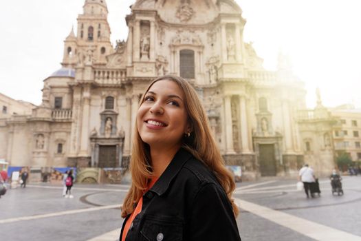 Tourist girl visiting Murcia with the Cathedral Church of Saint Mary on the background, Murcia, Spain