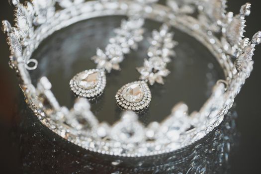 jewelry crown earrings on a glass table.