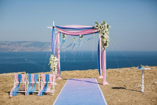 Wedding arch pink color on the background of the sea