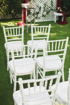 Beautiful white wedding chairs at the ceremony in the Park