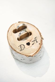 Wedding rings in a box made of birch wood with initials.