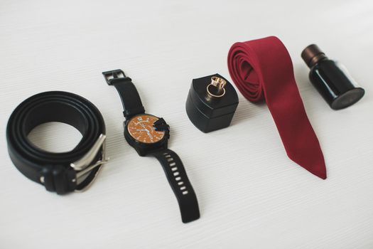 Men's accessories: belt, watch, tie and rings.