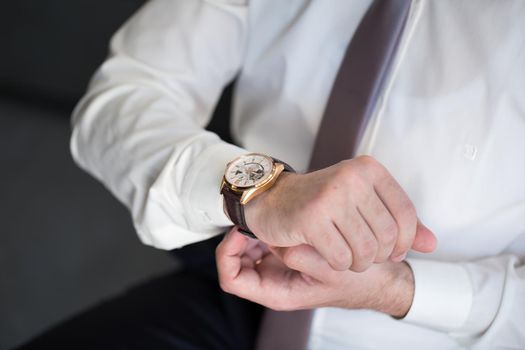 A man puts a watch on his hand.