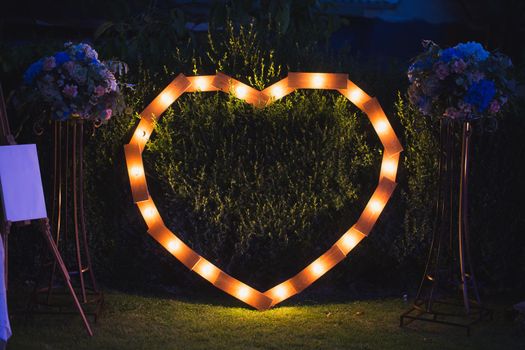 Handmade heart illuminated by light bulbs at a wedding